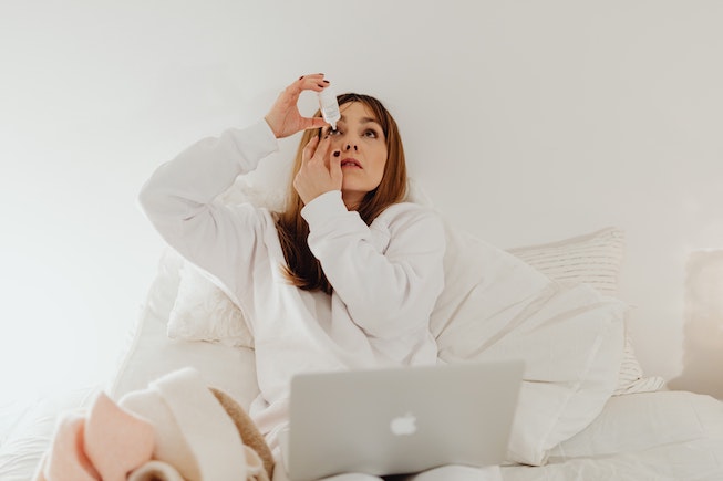 woman putting eye drops